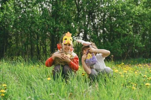 Two children hunt for Easter eggs in a spring garden. Easter tradition Stock Photos