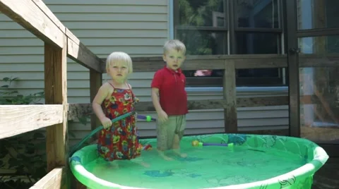 Two children in a kiddie pool deciding what to do before dancing Stock Footage 40027954