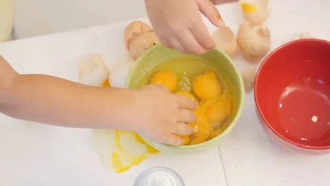 Two children in the kitchen. Child mix egg into a bowl in the kitchen Stock Footage 78280577