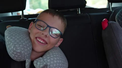 Two children laughing happily while sitting buckled up in the back seat of car Stock Footage 299894573