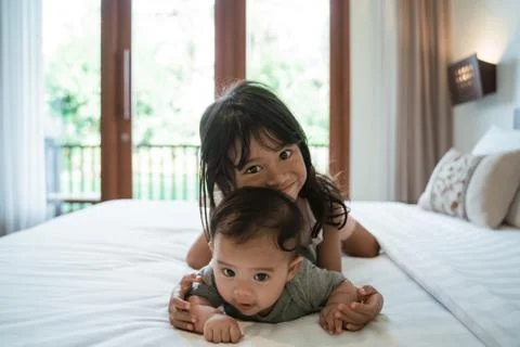 Two children lie in bed while playing together Stock-Fotos