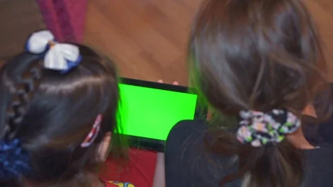 Two children look at the tablet with a green screen Stock Footage 104779827