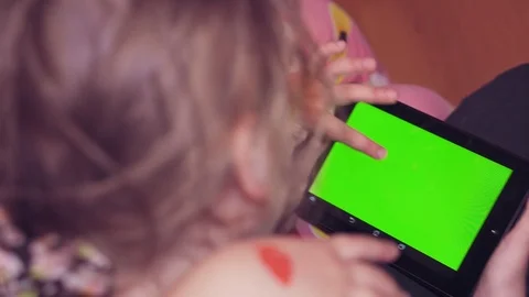 Two children look at the tablet with a green screen close up Stock Footage 104780316