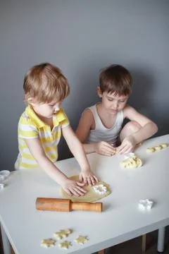 Two children make cookie mould on a white table. Preparation of homemade dess Stockfoto's