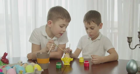 Two children paint an Easter egg with a brush Video stock 172327246