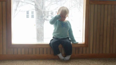 Two children play idly in front of a winter window Stock Footage 35801300