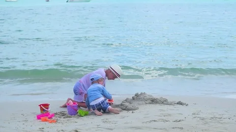 Two children play on a sandy beach with toys. Tropical island, hot day Vidéo 76165540