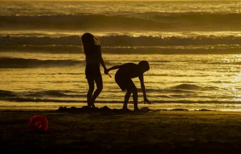 Two children playing on the beach. Stock Photos