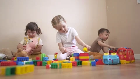 Two children playing with blocks. Group of children playing with toys in a Stock Footage 316603669