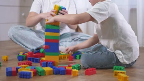 Two children playing with blocks. A group of children are assembling a Video stock 317690274