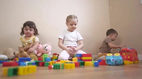 Two children playing with blocks. Group of children playing with toys in a Stock Footage 317714230