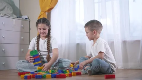 Two children playing with blocks. A group of children are assembling a Video stock 320837143