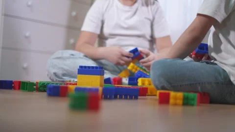 Two children playing with blocks. A group of children are assembling a Video stock 320838598
