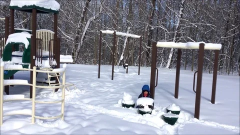 Two children playing in heavy snow in a city playground in Canada Stock Footage 104127097