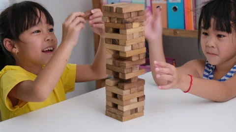  Two children playing Jenga board game on table in room at home. Vídeos de archivo 240379252