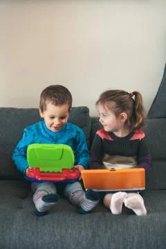 Two children playing with laptops learning basic digits, characters, sounds a Stock Photos