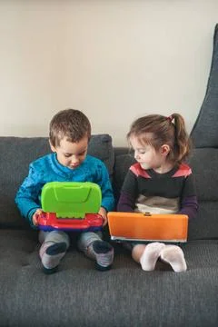 Two children playing with laptops learning basic digits, characters, sound... Stock Photos