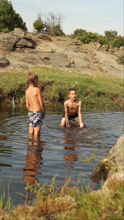 Two children playing in a natural pool in summer Stock Footage 277194346