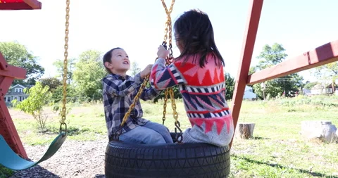 Two children playing with playground equipment 스톡 동영상 161970489