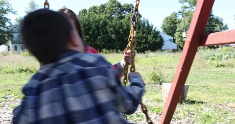 Two children playing with playground equipment Stock Footage 161970654