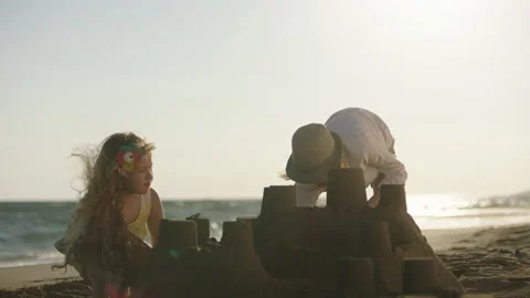 Two children playing with sand on beach Stock Footage 155890736