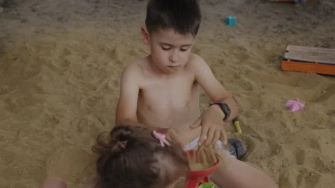 Two children playing on sandy ground in a summer day. The concept of learning Stock Footage 247141650