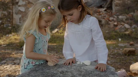 Two children playing with shells and sto... | Stock Video | Pond5