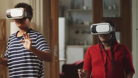 Two children playing video games in VR headsets, enjoying virtual reality Stock Footage 337089705