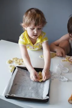 Two children put cookies on a baking sheet. homemade desserts. The view from  Stock Photos