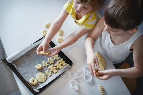 Two children put cookies on a baking sheet. homemade desserts. The view from  Stock Photos