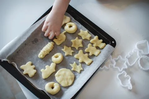 Two children put cookies on a baking sheet. homemade desserts. The view from  Stock Photos