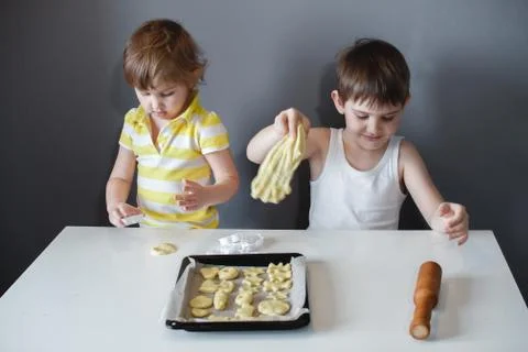 Two children put cookies on a baking sheet. homemade desserts. Stock Photos