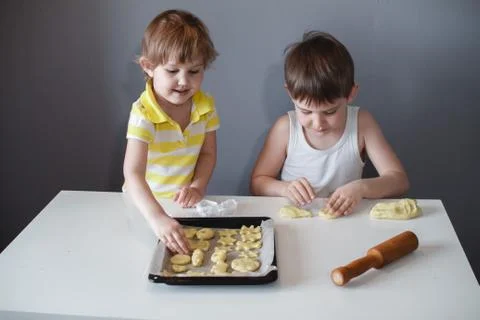 Two children put cookies on a baking sheet. homemade desserts. Foto stock