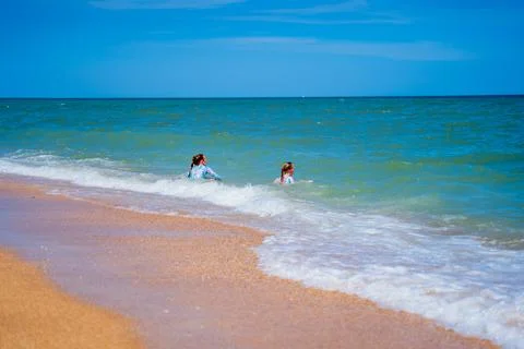 Two children, a red-haired girl and a blonde girl on the seashore Stock Photos