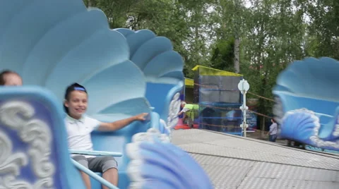 Two children ride on the carousel in an amusement park Stock Footage 65726660