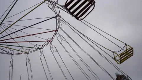 Two children ride a circular carousel on chains against Stock Footage 150403638