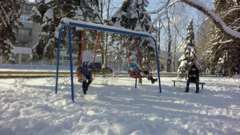 Two children ride on a swing. The boy is sitting on the bench. 库存影片 88243078