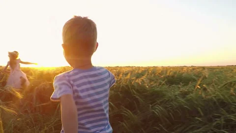 Two children run in the field at sunset. Stock Footage