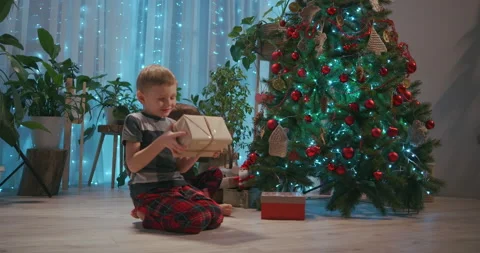 Two children running towards their presents on Christmas morning. Two boys in Vídeos de archivo 146226251