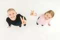 The two children show two finger on the white background. View from above Photo