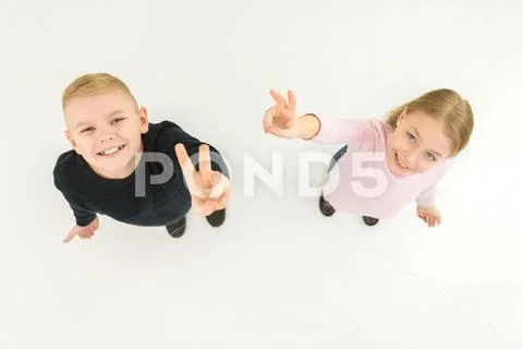 The two children show two finger on the white background. View from above Stock Photos
