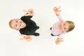 The two children show two finger on the white background. View from above Photo
