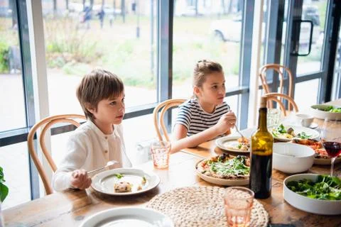Two children sitting at the dinner table Stock Photos