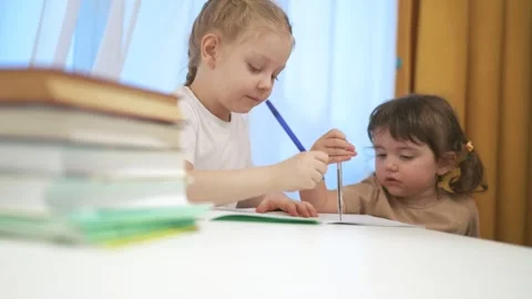 Two children sitting at table with laptop. Group of children are doing remote Video stock 317714632
