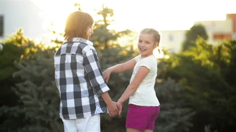 Two Children Stand Back And Hold Hands. Portrait of the Children's Back in the Stock Footage 98612674