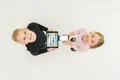 The two children stand with devices. View from above Photo