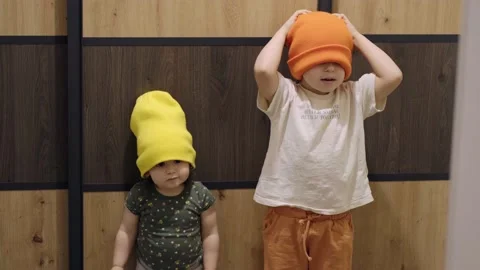 Two children standing next to each other and posing while wearing a hat, one Stock Footage 197737788