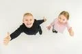 The two children thumb up on the white background. View from above Photo