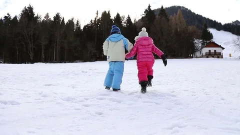 Two children walk in the snow 스톡 동영상 84757351