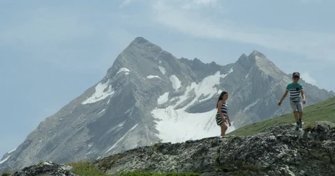Two children walking across a high mountain ridge and glaciers. Stock-Footage 78028378
